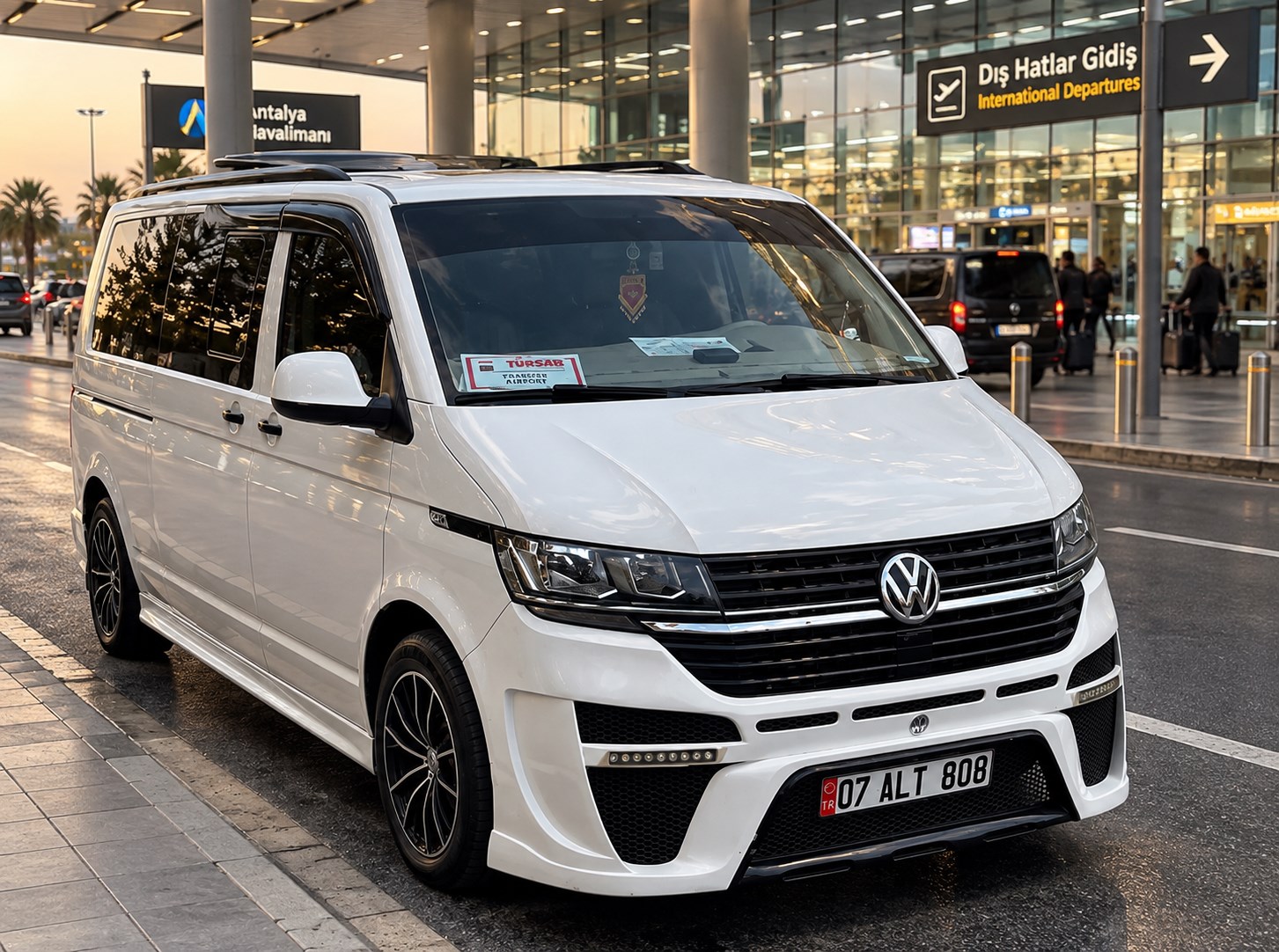 White Volkswagen van outside the Antalya Airport terminal.